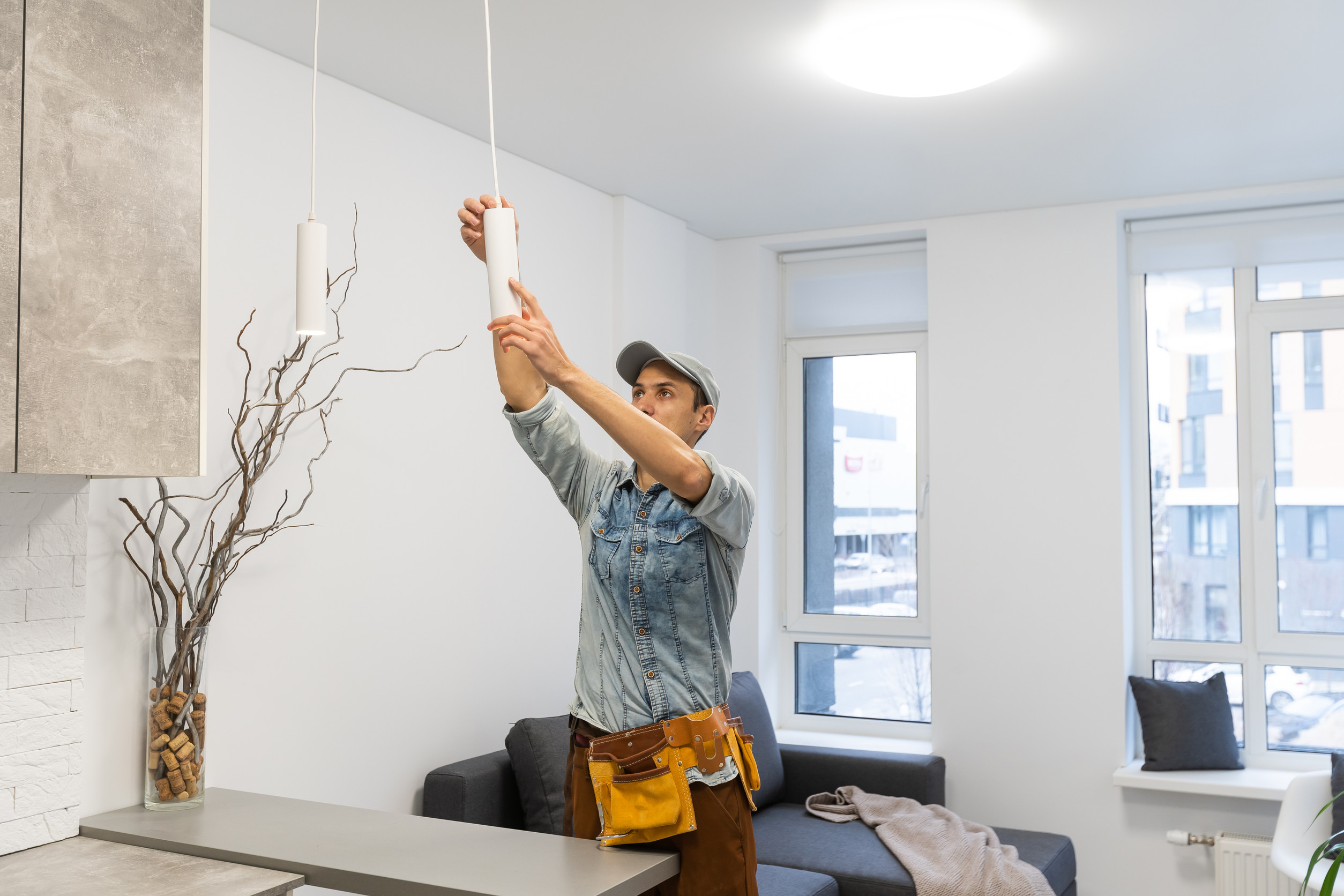 Electrician adjusting a ceiling light fixture.